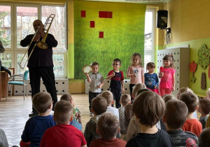 Przedszkolaki grają na grzechotkach,dzwoneczkach i tamburyno