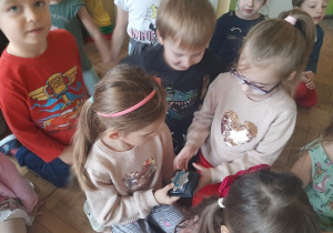 Przedszkolaki oglądają odznakę policyjną