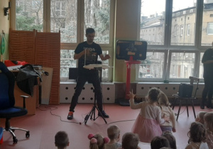 Dzieci słuchają z uwagą jaki dźwięk wydaje theremini