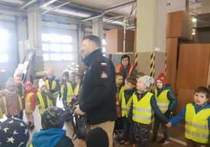 Dzieci słuchają ciekawostek na temat pracy strażaka