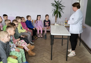 Dzieci słuchają objaśnień na temat przeprowadzanych eksperymentów
