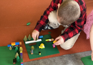 Chłopiec buduje z klocków lego