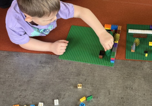 Chłopiec buduje z klocków lego