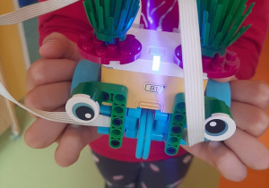 Dziewczynka prezentuje skonstruowanego robota