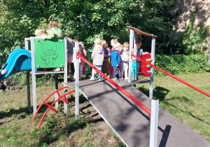 Dzieci czekają na swoją kolej, żeby zjechać na zjeżdżalni