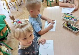 Dzieci kolorują kredkami