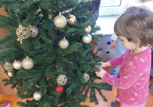 Dziewczynka wiesza kolorową bombkę