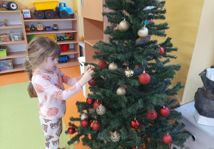 Dziewczynka ubiera choinkę