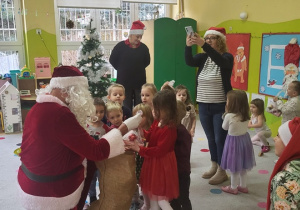 Mikołaj wręcza dzieciom prezenty