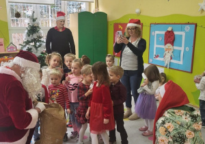Mikołaj wręcza dzieciom prezenty
