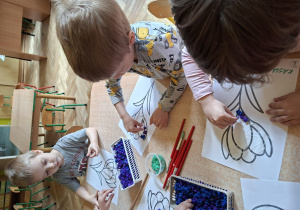 Dzieci wyklejają kuleczkami z bibuły