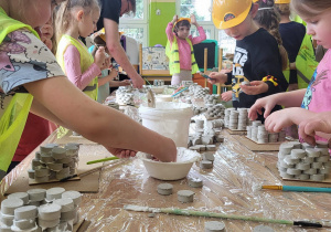 Dzieci sklejają koszyczki z gipsowych krążków