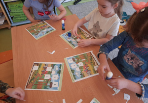 Dziewczynki naklejają brakujące obrazki w odpowiednim miejscu